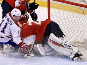 Montreal Canadiens' Brendan Gallagher, left, crashes into Florida Panthers' goaltender Reto Berra during NHL action Monday night in Sunrise, Fla. The Canadiens clinched first place in the Atlantic Division by virtue of a 4-1 victory.