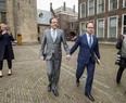 Dutch leader of the Democrats 66 (D66) party Alexander Pechtold, left, and party member Wouter Koolmee, right, arrive for a meeting with other Dutch political parties, at The Hague on April 1. They are holding hands to show solidarity for a gay couple that was attacked in the country.