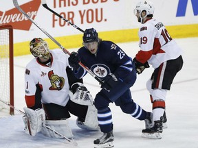 Patrik Laine celebrates Jets teammate Mathieu Perreault's game winning goal against Ottawa Senators goalie Mike Condon during third period action in Winnipeg on Saturday night.