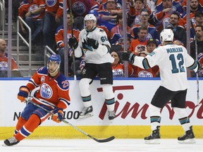 San Jose Sharks' Melker Karlsson and Patrick Marleau celebrate Karlsson's winning goal in overtime as the Oilers' Darnell Nurse skates past during playoff action in Edmonton on Wednesday night.