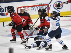 Finland's Noora Tulus (24) and Emma Nuutinen (22) celebrate the winning goal against Canada at the women's world hockey championship in Plymouth, Mich., on Saturday night.