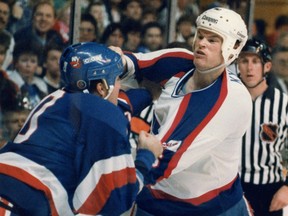 In this April 25, 1989 file photo, former Winnipeg Jets defenceman Jim Kyte (right) fights New York Islanders winger Dale Henry.