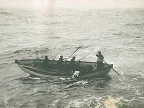 Crew members of the recovery ship CS Minia pulling a lifebelted Titanic victim from the sea.