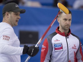 Team USA skip John Shuster, left, follows the progress of an incoming rock while Canadian skip Brad Gushue looks on during action at the world men's curling championship Monday in Edmonton. Gushue improved to 5-0 with an 8-2 win over Shuster.