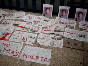 A message that reads in Spanish “No More Deaths” is written in red paint on newspapers placed in front of photos of slain journalist Miroslava Breach, at a demontration in Mexico City on March 25, 2017.