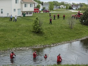 In this Wednesday, April 26, 2017 photo, emergency divers search the water for a toddler in Joliet, Ill.