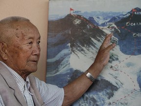 Nepalese climber Min Bahadur Sherchan, points to a picture to describe the trail to Mount Everest, as he talks to Associated Press at his residence in Kathmandu, Nepal.