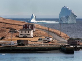 A large iceberg is visible from the shore in Ferryland, an hour south of St. John's, Newfoundland on Monday, April 10, 2017. A towering iceberg stationed off Newfoundland's east coast is drawing dozens of people to the small shoreline community sitting in its shadow. THE CANADIAN PRESS/Paul Daly