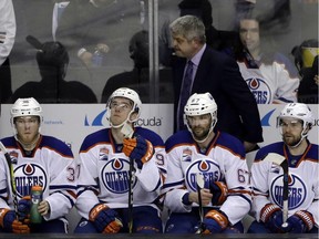 Edmonton Oilers coach Todd McLellan, top, and his players watch from the bench in the closing minutes of a 7-0 loss to the San Jose Sharks on April 18.