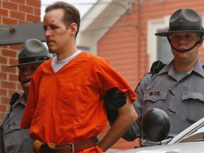 In this Oct. 31, 2014 file photo Eric Frein is escorted by police into the Pike County Courthouse for his arraignment in Milford, Pa. Frein a survivalist who eluded capture for 48 days after allegedly killing a trooper in a 2014 ambush says police were about a football field away from him at one point during the manhunt.