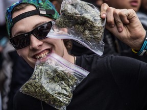 A man holds up and poses with bags of pot during the annual 4/20 pro-marijuana rally at the Vancouver Art Gallery in Vancouver, B.C. on Sunday April 20, 2014.