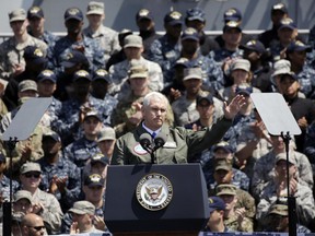 Mike Pence, front, waves to U.S. servicemen and Japanese Self-Defense Forces personnel on the flight deck of U.S. navy nuclear-powered aircraft carrier USS Ronald Reagan