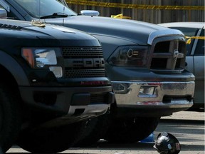 A hardhat sits on the ground next to two pick-up trucks as Edmonton Police Service members investigate a shooting that occurred at approximately May 25, 2015.