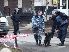 Russian police officer with a dog crosses a police line in St.Petersburg, Russia Thursday, April 6, 2017