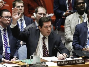 Russian Deputy U.N. Ambassador Vladimir Safronkov shows his hand to vote against a resolution condemning Syria's use of chemical weapons on Wednesday.