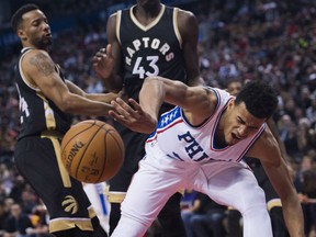 Timothe Luwawu-Cabarrot of the Philadelphia 76ers is stripped of the ball by Toronto Raptors' Norman Powell, left, during NBA action Sunday in Toronto. The Raptors were 113-105 winners.