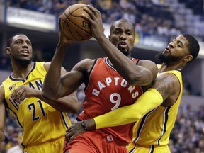 Paul George of the Indiana Pacers fouls Toronto Raptors forward Serge Ibaka during the first half of their game in Indianapolis on Tuesday night.