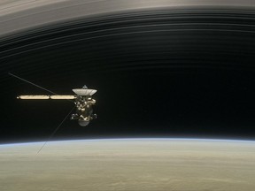 This image made available by NASA in April 2017 shows a still from the short film "Cassini's Grand Finale," with the spacecraft diving between Saturn and the planet's innermost ring.