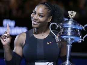 In this Jan. 28 file photo, Serena Williams holds up a finger and her trophy after defeating her sister, Venus, in the women's singles final at the Australian Open.