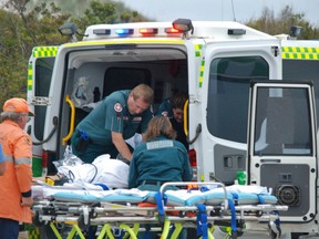Emergency services staff work on a 17-year-old girl attacked by a shark Monday in Australia.