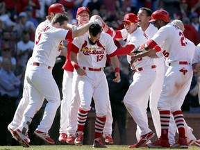 The St. Louis Cardinals' Matt Carpenter (13) is congratulated by teammates after hitting a walk-off grand slam to defeat the Toronto Blue Jays 8-4 in 11 innings in the first game of a doubleheader Thursday, April 27, 2017.