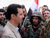 Syrian President Bashar Assad, left, talks to government soldiers during his visit to the Christian village of Maaloula, near Damascus in April 2014.
