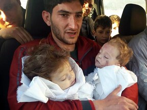 In this picture taken on Tuesday April 4, 2017, Sabdul-Hamid Alyousef, 29, holds his twin babies who were killed during a suspected chemical weapons attack, in Khan Sheikhoun in the northern province of Idlib, Syria.
