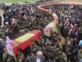 Fighters from the predominantly-Kurdish Syrian Democratic Forces carrying the coffins of their comrades, who were killed Tuesday by a misdirected airstrike by the U.S.-led coalition, during their funeral procession, in Tal al-Abyad, northeast Syria, Thursday, April 13, 2017.