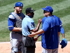Home plate umpire Ramon De Jesus talks with Toronto Blue Jays manager John Gibbons and catcher Russell Martin on April 23.