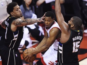 Toronto Raptors guard Kyle Lowry looks to pass between the Milwaukee Bucks' Michael Beasley and Greg Monroe during Game 1 of their NBA playoff series on Saturday, April 15, 2017.