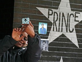 In this April 22, 2016, file photo, a fan takes a selfie by the Prince star and memorial at First Avenue in Minneapolis where he often performed. The one-year anniversary of the pop super star's death from an overdose will be marked April 21.