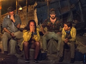 In this image released by CBS, contestants, from left, Jeff Varner, Sarah Lacina, Zeke Smith and Debbie Wanner appear at the Tribal Council portion of the competition series "Survivor: Game Changers." Smith was outed as transgender by fellow competitor Varner on Wednesday nightís episode. Varner was immediately criticized by other players. He repeatedly apologized, but was voted out of the competition.