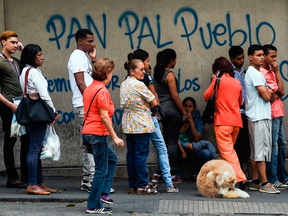 People line up to buy bread outside a bakery in Caracas as on March, 17, 2017.