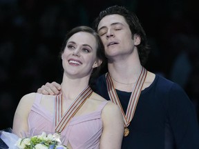 Tessa Virtue and Scott Moir, of Canada, react listening to the national anthem after winning the gold at the World figure skating championships in Helsinki, Finland, on Saturday, April 1, 2017.