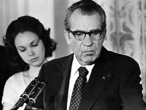 President RIchard Nixon announces his resignation at the White House in this Aug. 9, 1974 file photo. Looking on is his daughter, Julie Nixon Eisenhower