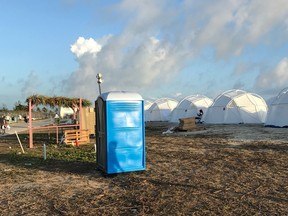 Tents and a portable toilet set up for attendees for the Fyre Festival, Friday, April 28, 2017 in the Exuma islands, Bahamas