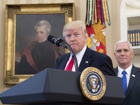 A portrait of former President Andrew Jackson hangs on the wall behind President Donald Trump, accompanied by Vice President Mike Pence, in the Oval Office at the White House.
