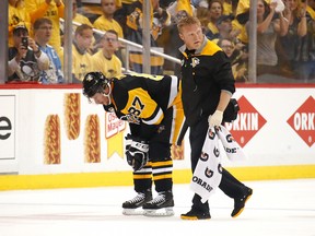 Sidney Crosby #87 of the Pittsburgh Penguins leaves the ice with trainer Chris Stewart after taking a hit in the first period while playing the Washington Capitals  in Game Three of the Eastern Conference Second Round during the 2017 NHL Stanley Cup Playoffs at PPG Paints Arena on May 1, 2017 in Pittsburgh, Pennsylvania.
