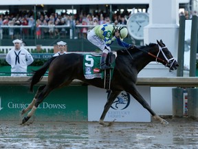 Jockey John Velazquez celebrates as he guides Always Dreaming across the finish line to win the 143rd running of the Kentucky Derby at Churchill Downs on May 6, 2017 in Louisville, Kentucky.