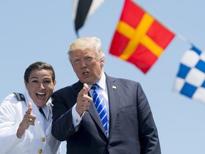 US President Donald Trump gestures with newly commissioned US Coast Guard Ensign Erin Reynolds during the US Coast Guard Academy Commencement Ceremony in New London, Connecticut, May 17, 2017.