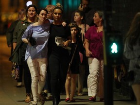 Police escort members of the public from the Manchester Arena on May 23, 2017 in Manchester, England