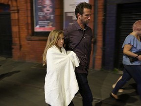 Police escort members of the public from the Manchester Arena on May 23, 2017 in Manchester, England.