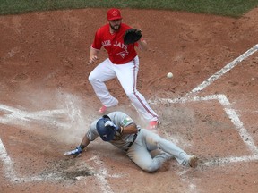 Texas Rangers infielder Elvis Andrus (below) scores on a wild pitch against the Toronto Blue Jays on May 28.