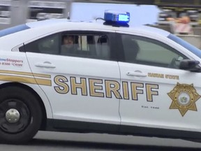 In this image made from video provided by Hawaii News Now, a man who was detained on an American Airlines flight is driven away from the plane after landing in Honolulu, Friday, May 19, 2017. Federal agents met the plane from Los Angeles when it landed in Honolulu and took the man into custody.