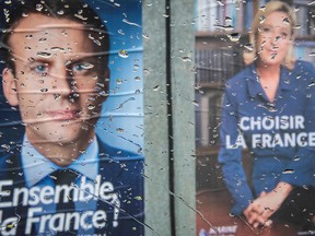 The posters of second round French Presidential elections candidates for the far-right Front National party Marine Le Pen (R) and for the En Marche ! movement Emmanuel Macron are seen through the wet windshield of a car parked in the town of Bacqueville-en-Caux, in Normandy.