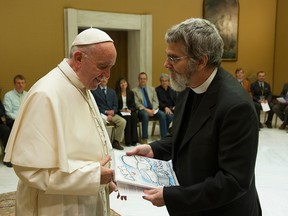 This handout picture released by the Vatican press office shows Pope Francis listening to Brother Guy Consolmagno, a Jesuit astronomer at the Vatican's Observatory, on May 12, 2017 during a meeting at the Vatican