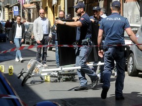 Italian police work around the bike that Giuseppe Dainotti was riding when he was murdered.