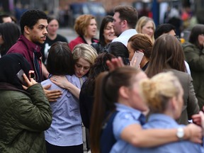 Retail staff hug each other after being evacuated from the Arndale Centre shopping mall in Manchester, northwest England on May 23, 2017
