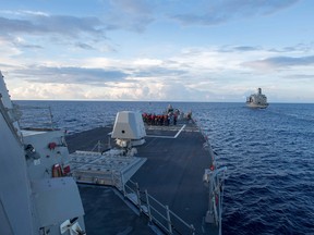 This handout photo taken in May by the U.S. Navy shows the Arleigh Burke-class guided-missile destroyer USS Dewey preparing for a replenishment-at-sea with the Henry J. Kaiser-class fleet replenishment oiler USNS Pecos in the South China Sea.