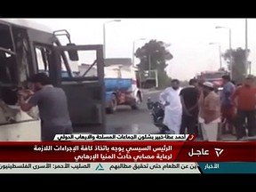 An image grab taken from Egypt's state-run Nile News TV channel on May 26, 2017 shows people inspecting the remains of a bus that was attacked while carrying Egyptian Christians in Minya province, some 260 kms south of the capital Cairo, killing dozens people according to state media and the health ministry.